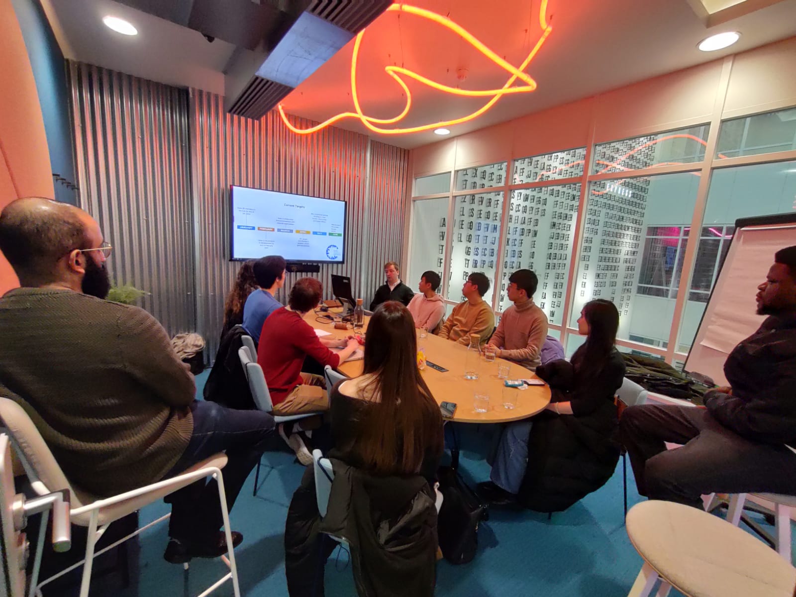 A group of young Global Shapers engaged in a monthly meeting around a table in Greater Manchester